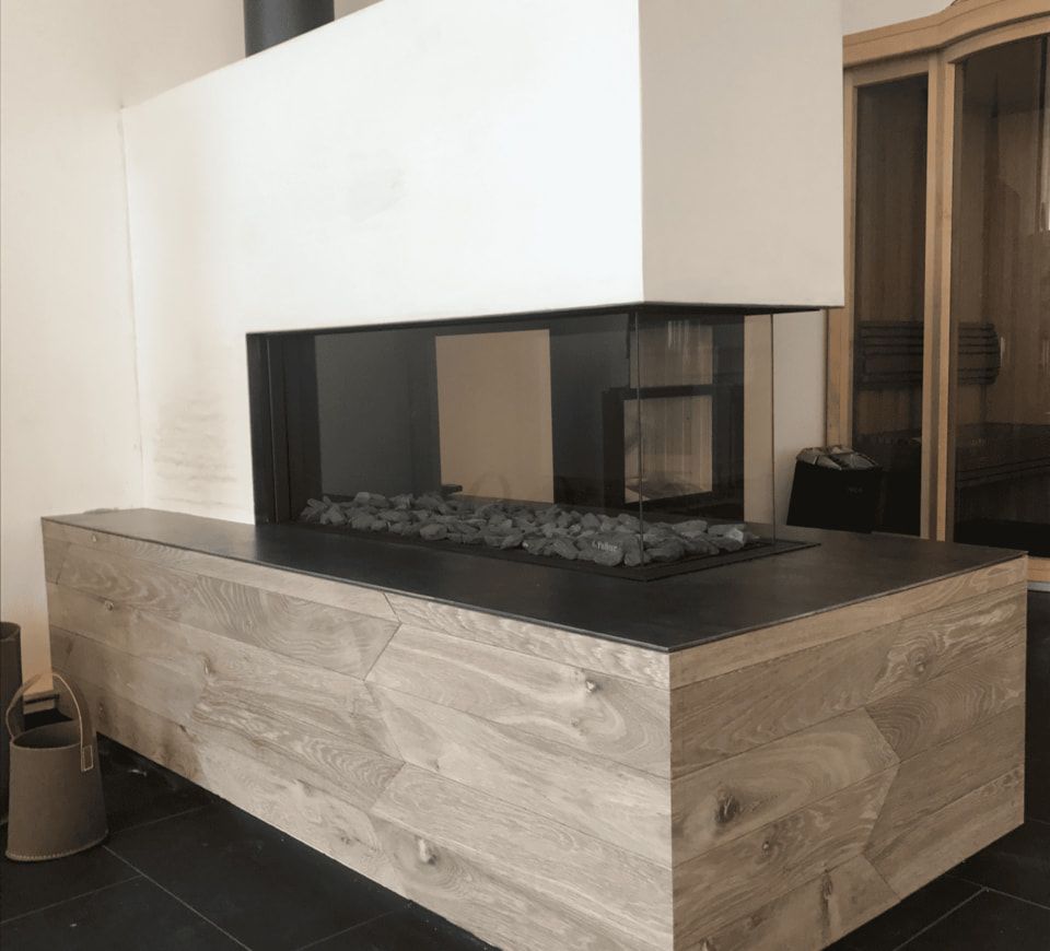 Moderne Feuerstelle mit einem Holzofen, der eine gemütliche Atmosphäre in einem stilvollen Raum schafft.